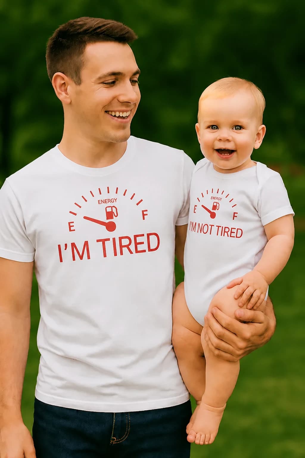 Isa valges T-särgis „I’m tired“ ja beebi bodis „I’m not tired“, kütusenäidikuga komplekt