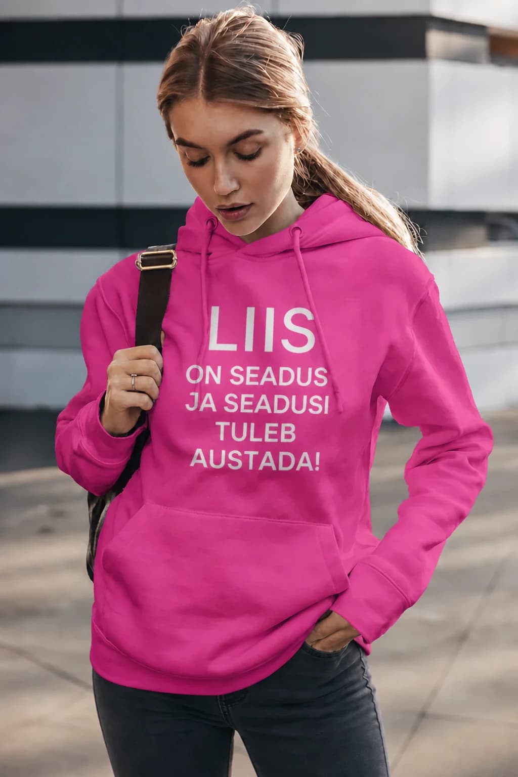 Tumeroosa naiste kapuutsiga pusa nimega ja kirjaga „Liis on seadus ja seadusi tuleb austada!“