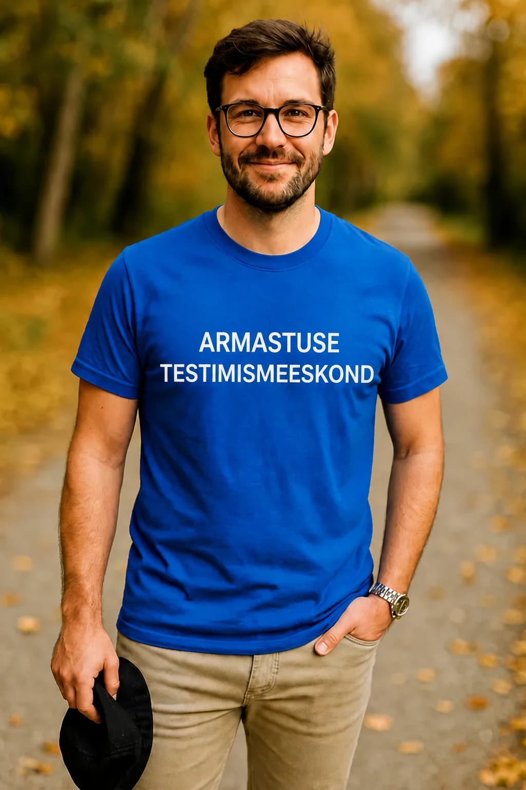 Kuningasinine naljakas T-särk valge kirjaga ARMASTUSE TESTIMISMEESKOND, kannab prillidega mees