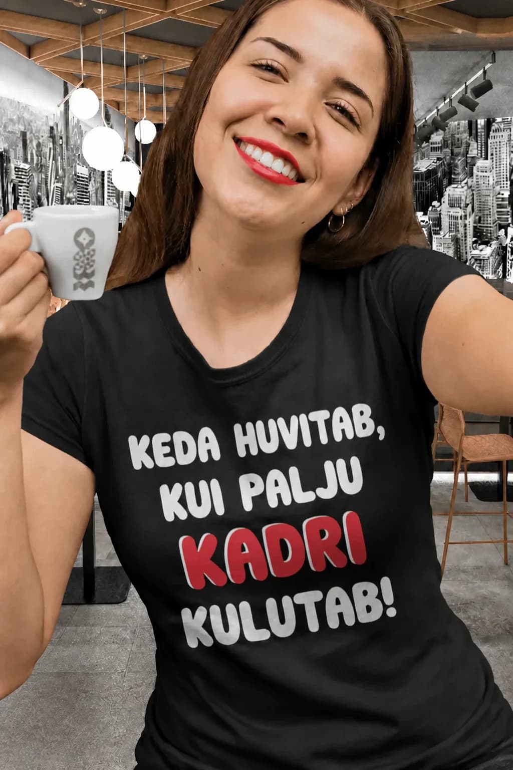 Naine mustas T-särgis kirjaga „Keda huvitab, kui palju Kadri kulutab!“, nimi punaselt – särk soovitud nimega